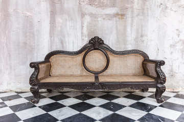 Antique sofa against old stucco background