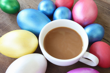 Easter eggs and Coffee cup on wood background.