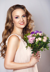 beauty portrait of a beautiful girl with bright spring bouquet