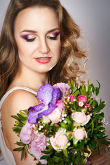 beauty portrait of a beautiful girl with bright spring bouquet