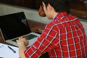 Fototapeta na wymiar Man eating with laptop at coffee shop