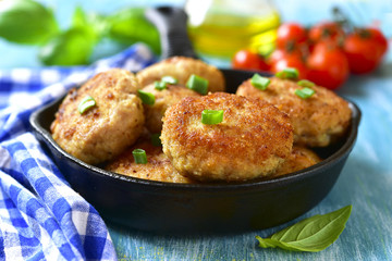 Chicken cutlests in a skillet.