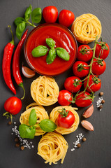 Tomato sauce with pasta on black background, top view