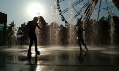 Roller skater silhouettes at fountain © yk_stock