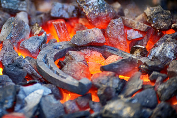 Blacksmith forges a horseshoe