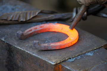 Blacksmith forges a horseshoe