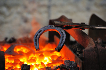 Blacksmith forges a horseshoe