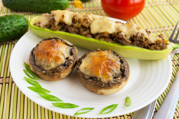 Baked stuffed mushrooms and zucchini on a white plate.