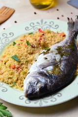 Cous cous with dorado fish on plate