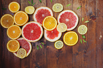 Vibrant citrus half cut fruits on old wooden table