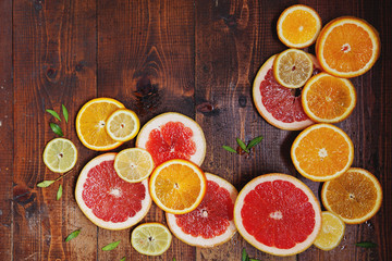 Vibrant citrus half cut fruits on old wooden table
