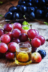 Essential oil of grape seeds and a fresh bunch of grapes, vintag