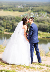 Fototapeta na wymiar groom kissing bride outdoors