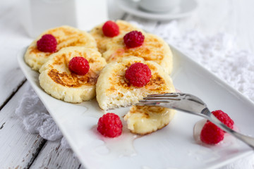 Homemade cottage cheese pancakes with raspberries and honey