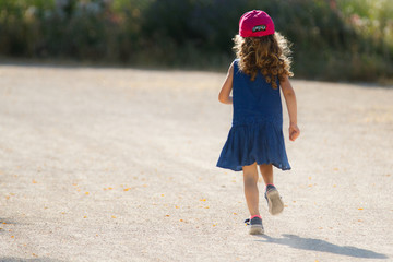 una ni&ntilde;a andando con un vestido azul