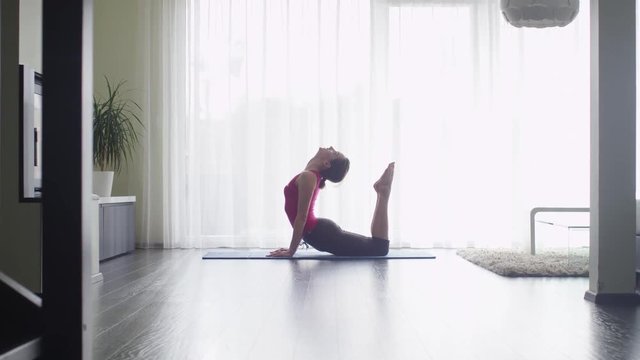 Young Woman doing Fitness in Living Room at Home. Shot on RED Cinema Camera.
