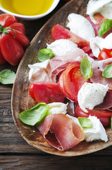 Italian salad caprese with ham, basil and mozzarella