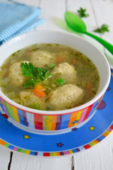 Light soup with meatballs and green peas, dinner for children