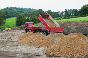 LKW liefert Schotter an eine Baustelle - Baustelle, Kiesgrube Bagger, Schotter