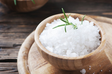 Sea salt and fresh rosemary on the wooden table