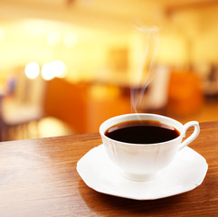 Cup of coffee on table on blured cafe background