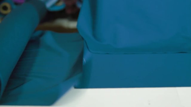 Tailors cutting supplies for sewing shirt