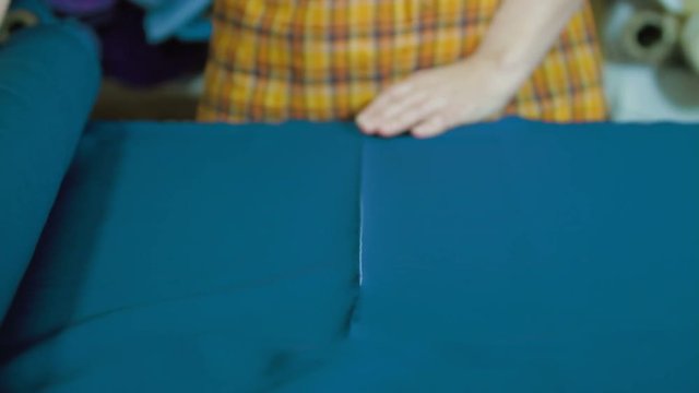Tailors cutting supplies for sewing shirt