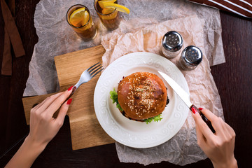 First person view of a woman preparing eat burger.