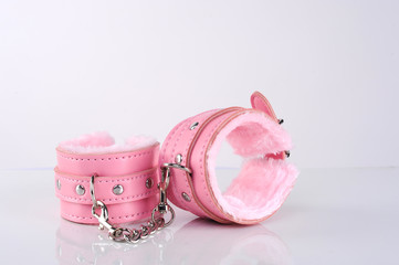 pink sexy handcuffs connected with chain on white screen isolated