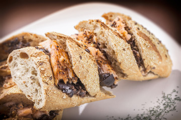 turkey breast sandwich with black mushrooms pesto sauce on white plate