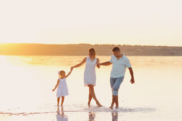 Мама, папа и маленькая дочь грают в море