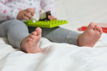 Legs of  child sitting on the bed