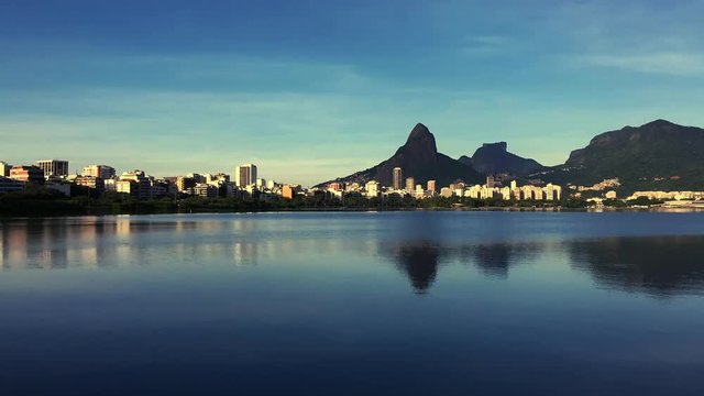 Scenic skyline morning time lapse of Lagoa Rodrigo de Freitas lagoon in Rio de Janeiro Brazil with Ipanema and Leblon reflecting on the calm horizon 