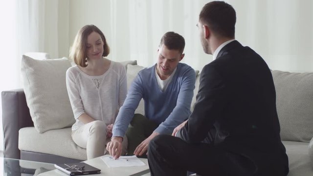 Happy Family Signing Contract with Real-estate Agent. Shot on RED Cinema Camera.