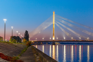 Fototapeta na wymiar Cable-stayed bridge and embankment of the River Daugava during twilight blue hour, Riga, Latvia