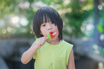 Asian child eating an ice cream outdoors