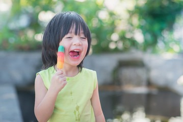Asian child eating an ice cream outdoors