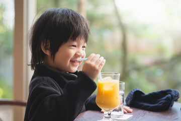 child drinking fresh orange juice