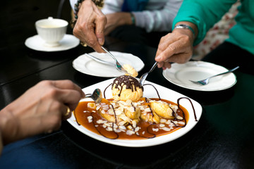 family enjoying having bananas crepe and  ice cream