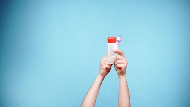Woman hands holds toothbrush and paste for teeth cleaning 4K