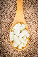 Seeds of beans with wooden spoon on jute canvas, healthy food