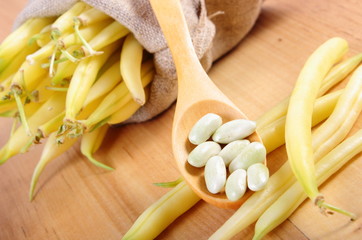 Seeds and heap of yellow beans in jute bag, healthy food
