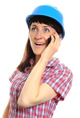 Builder woman in protective helmet talking on mobile phone