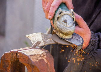 sharpening garden tools hoe using grinder close-up, Machine for