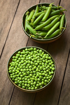 Peas (lat. Pisum sativum) and closed peapods in bowls (Selective Focus, Focus on the lower half of the peas in the bowl)
