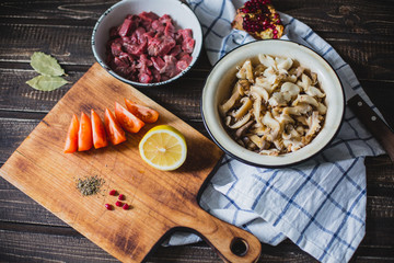 meat, mushrooms, tomatoes, vegetables and spices lie 