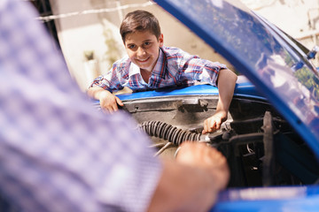 Boy Fixing Car Engine With Old Man Grandpa