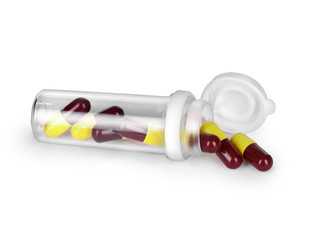Pills spilling out of pill bottle isolated on white background