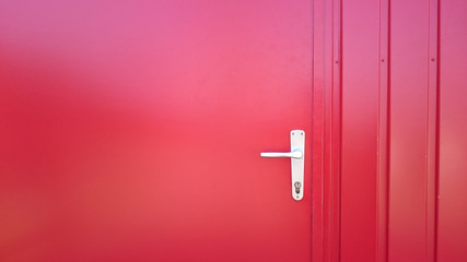 closed red metal door with handle and key hole