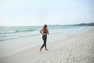 Fototapeta na wymiar A woman jogging on the beach